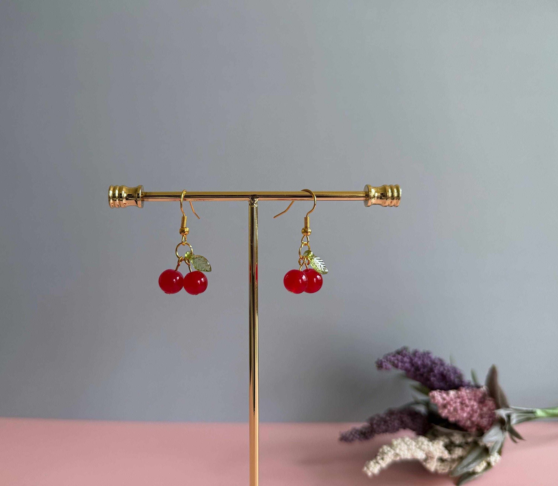 Red cherry earrings on a stand