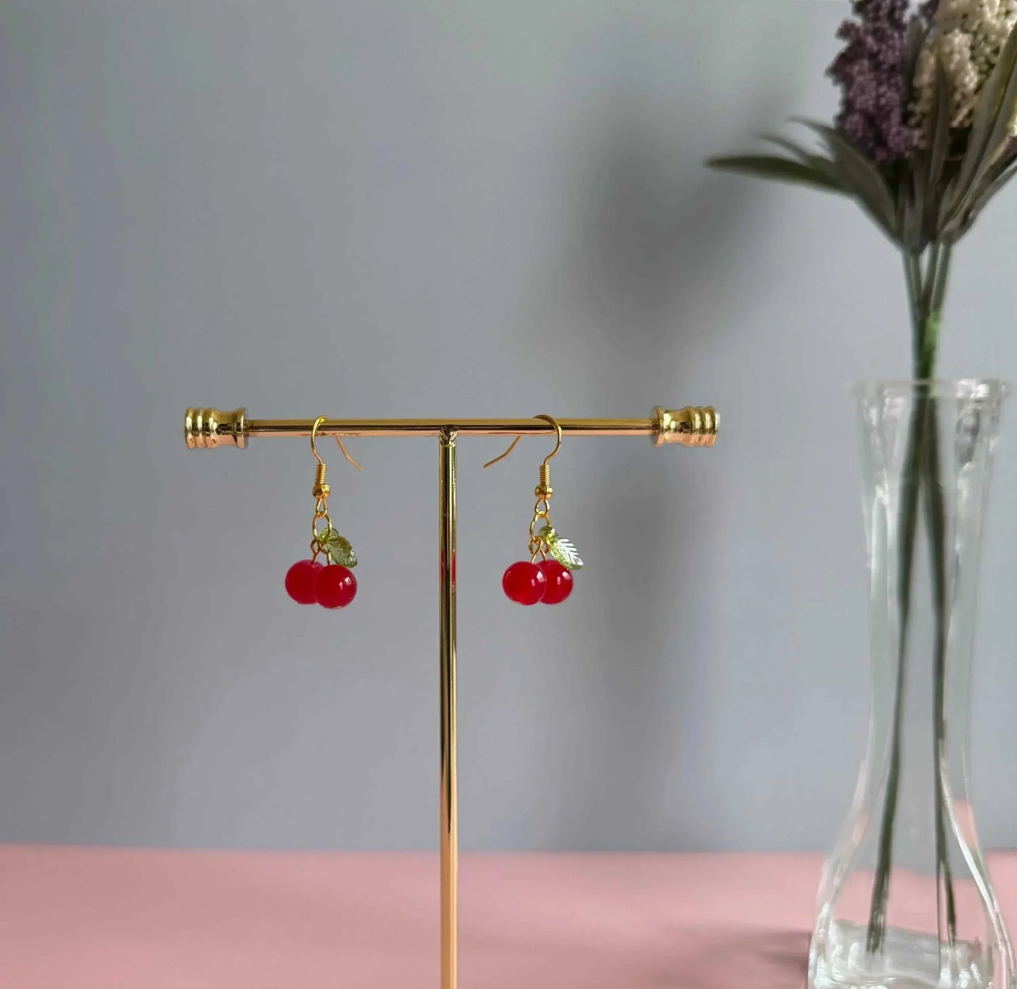 Red cherry earrings on a stand