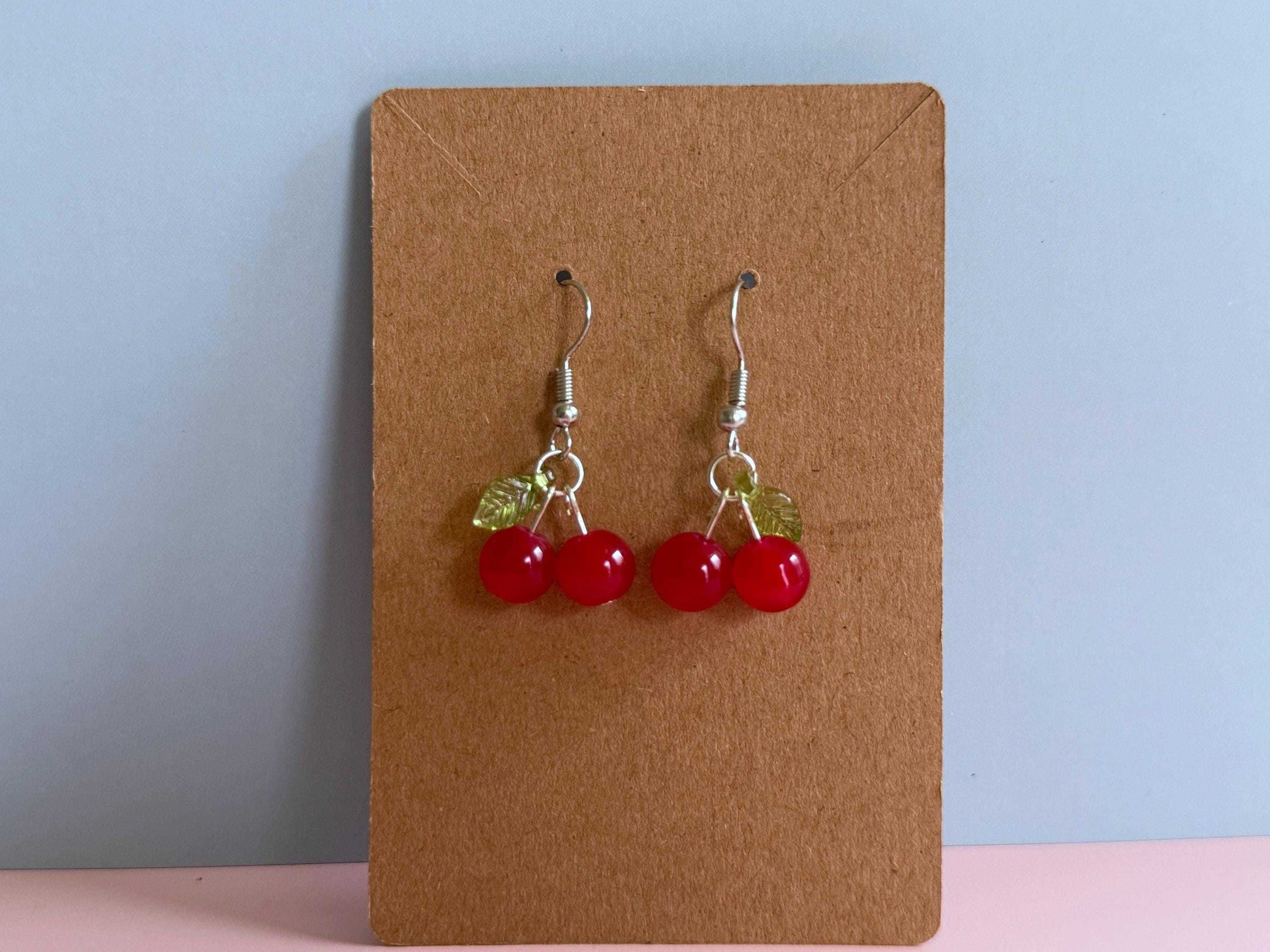 Red cherry earrings on an earring card