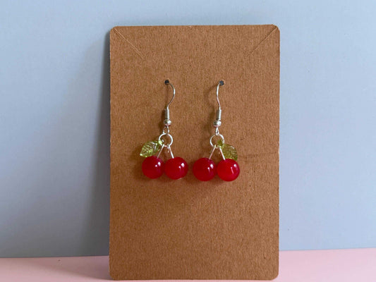 Red cherry earrings on an earring card